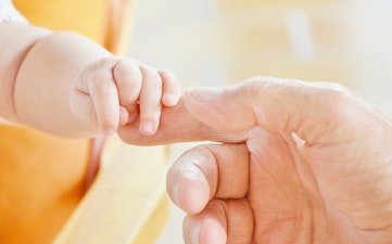baby holding an adult hand